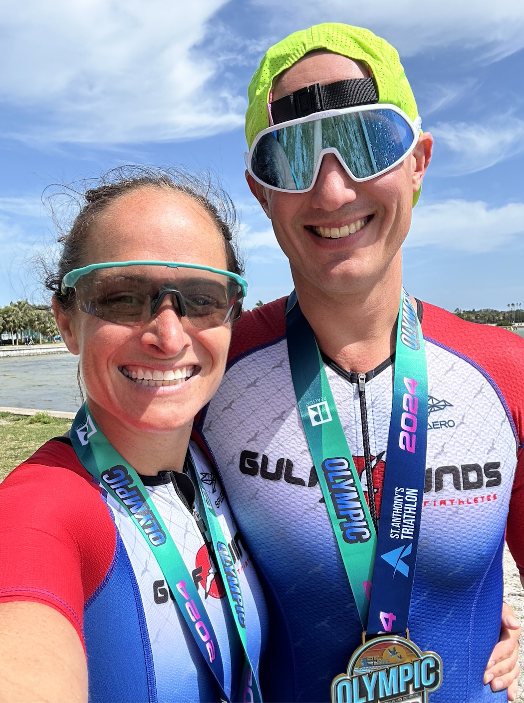 a male and female triathlete with medals
